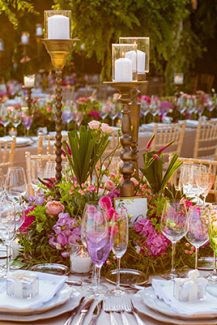 Μοντέρνος στολισμός τραπεζιών δεξίωσης γάμου με έντονα χρώματα, λουλούδια και κεριά