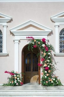 Πανέμορφος στολισμός εισόδου εκκλησίας με πλούσιες συνθέσεις λουλουδιών και πρασινάδα