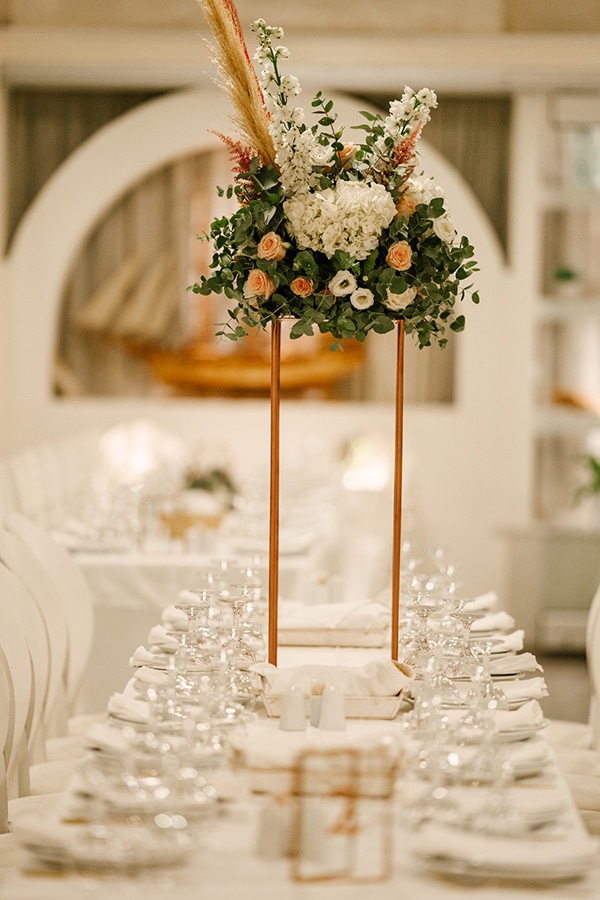 Elegant centerpieces για δεξιωση γαμου με λουλουδια και πρασιναδα σε χρυσα stands