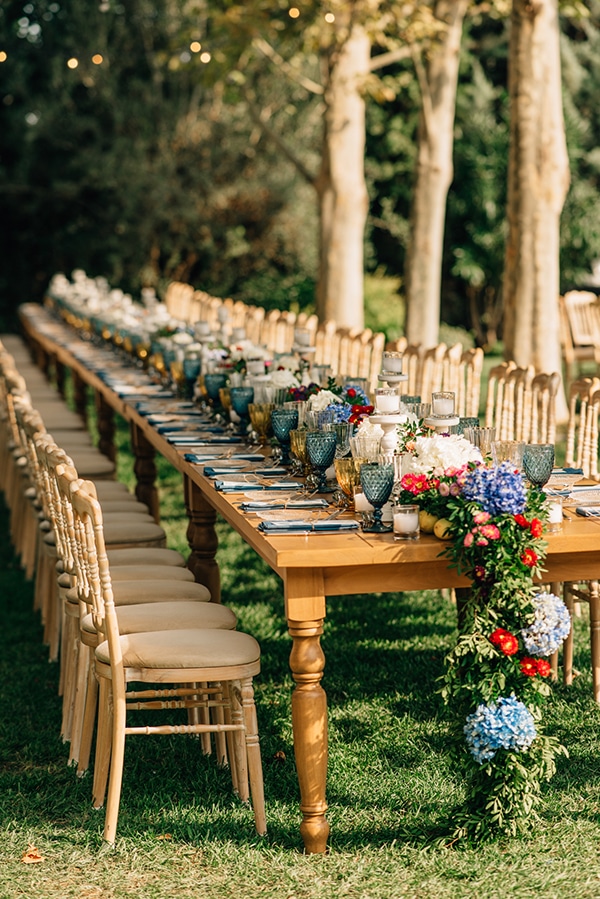 Στολισμός δεξίωσης εξωτερικού χώρου με ξύλινα τραπέζια και λουλούδια