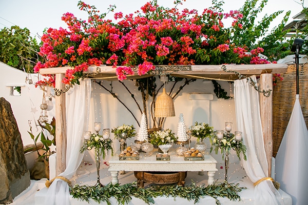 Dessert table γάμου διακοσμημένο με λουλούδια και κεριά