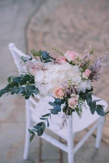 Στολισμός καρέκλας καλεσμένων για τελετή γάμου με τριαντάφυλλα, ορτανσίες και ευκάλυπτο