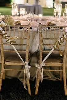 Στολισμός καρέκλας για νεόνυμφους με χρυσές πινακίδες “Bride – Groom”