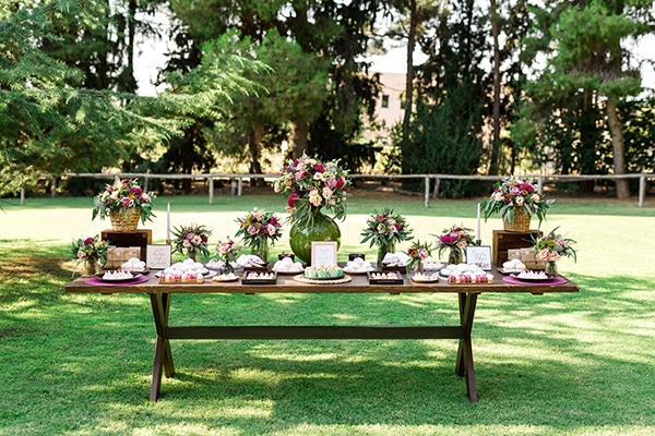 Ξύλινο candy table εμπλουτισμένο με πολύχρωμα λουλούδια