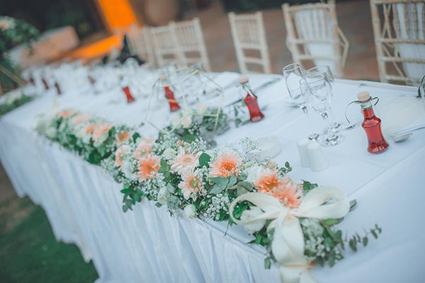 Ρομαντικός στολισμός γαμήλιου τραπεζιού με ανοιξιάτικα λουλούδια σε coral αποχρώσεις