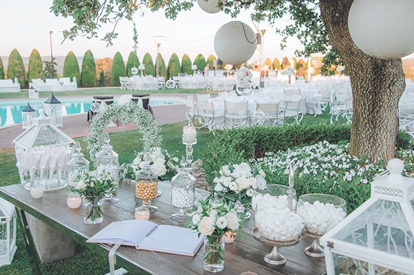 Τραπέζι ευχών διακοσμημένο με λευκά τριαντάφυλλα και γλυκήσματα