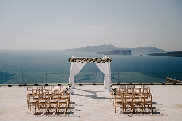 Υπέροχη αψίδα τελετής γάμου με λευκά άνθη, λευκά υφάσματα και θέα το Αιγαίο πέλαγος