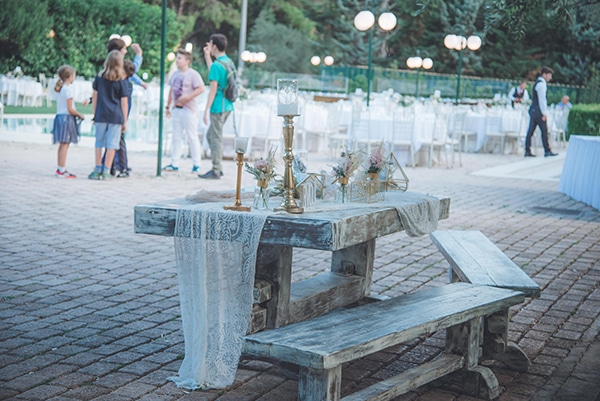 Στολισμός εισόδου εκκλησίας με χρυσούς αμφορείς και λευκό ύφασμα σε ξύλινο black and white τραπέζι