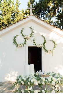 Πρωτότυπος στολισμός εισόδου εκκλησίας με στεφάνια από ευκάλυπτο και λευκά λουλούδια