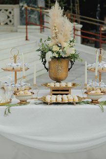 Candy table με λευκό ύφασμα και vintage χρυσές βάσεις