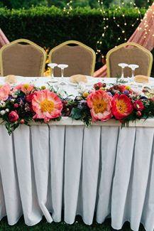 Ανοιξιάτικος στολισμός γαμήλιου τραπεζιού με λουλούδια σε ζωηρά χρώματα
