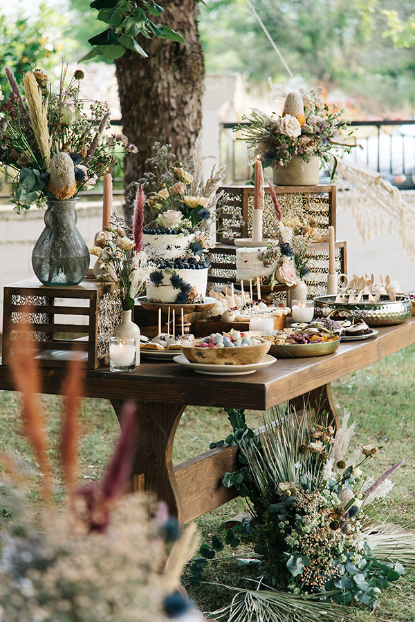Ξύλινο dessert table διακοσμημένο με vintage βάζα και ξεχωριστά λουλούδια που εντυπωσιάζουν