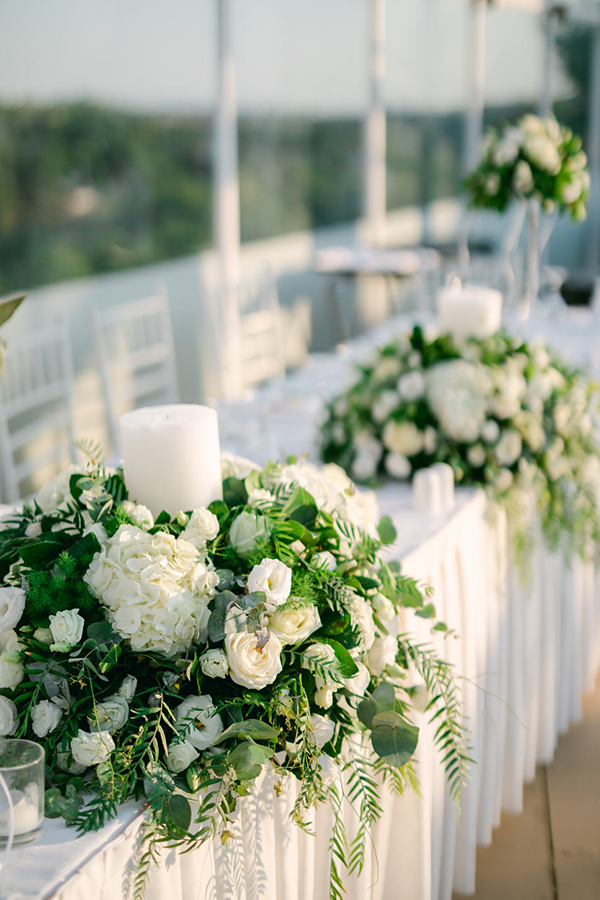 Πλούσιος ανθοστολισμός γαμήλιου τραπεζιού με ρομαντικά λευκά άνθη