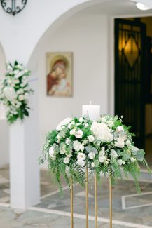 Ρομαντικός στολισμός εισόδου εκκλησίας με πλούσιο ανθοστολισμό από λευκά άνθη και πρασινάδα