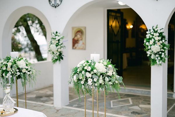 Ρομαντικός στολισμός εισόδου εκκλησίας με πλούσιο ανθοστολισμό από λευκά άνθη και πρασινάδα