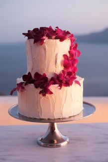 Λευκή δίπατη τούρτα γάμου με άνθη βουκαμβίλιας