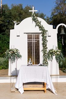 Πανέμορφος στολισμός εισόδου εκκλησίας με πρασινάδες σε γιρλάντα και λευκά άνθη