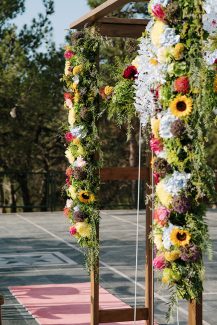 Πολύχρωμη ξύλινη αψίδα λουλουδιών με sunflowers