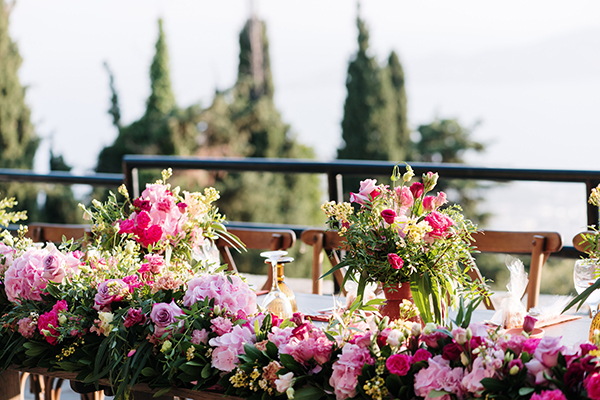 Πλούσιος στολισμός γαμήλιου τραπεζιού με γιρλάντα από φούξια λουλούδια