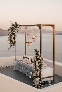 Stylish στολισμός γαμήλιου τραπεζιού με λευκά τριαντάφυλλα και πολυελαίους