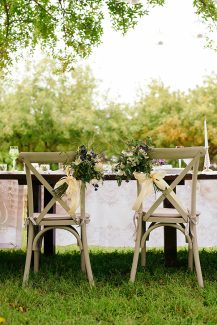 Ιδιαίτερος στολισμός καρέκλας γάμου με μπουκέτο λουλουδιών και σατέν κορδέλα