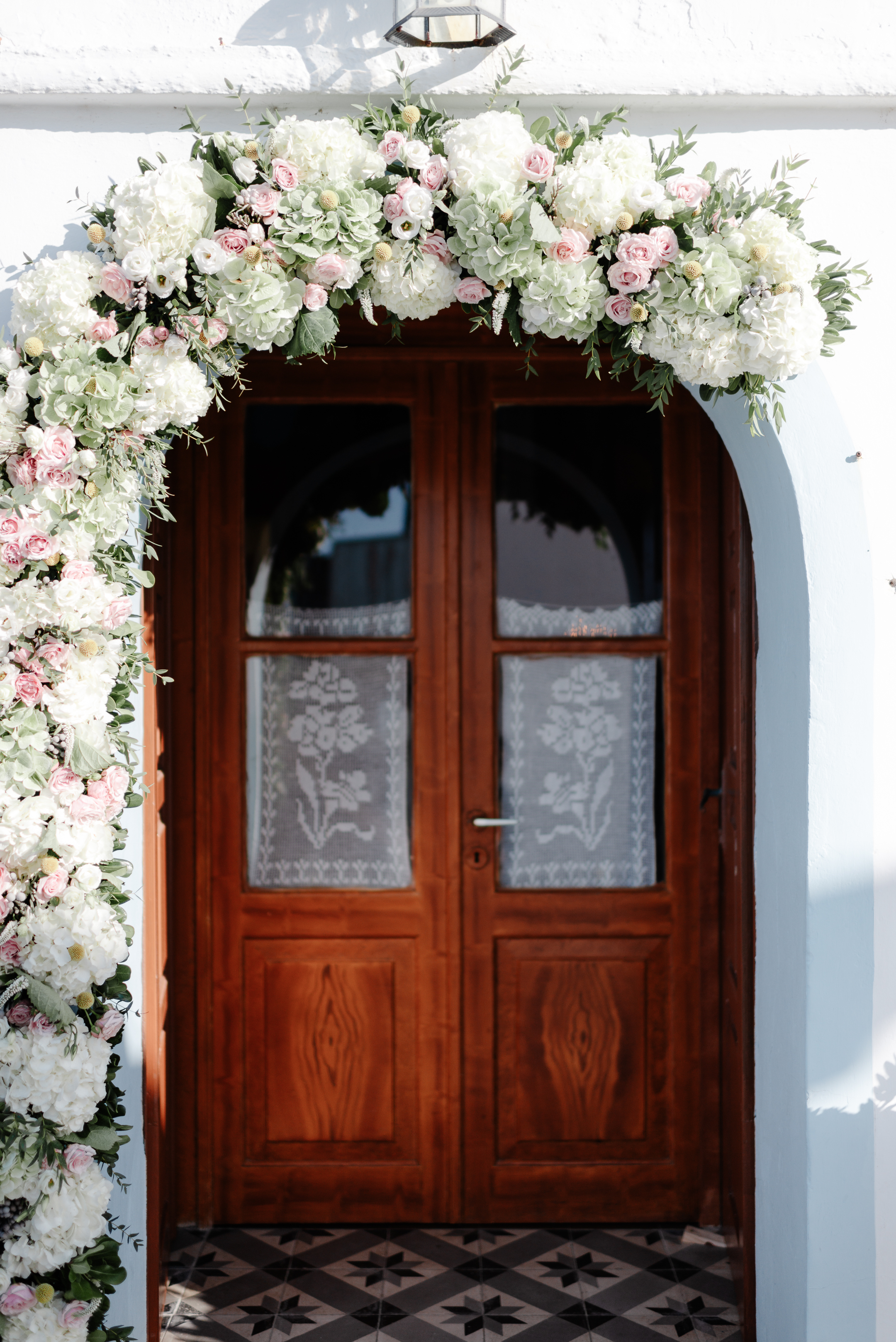 Ρομαντικός στολισμός εισόδου εκκλησίας με λουλουδένια γιρλάντα