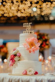 Τρίπατη τούρτα γάμου με πολύχρωμα λουλούδια