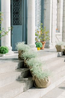 Στολισμός εισόδου εκκλησίας με γυψοφίλη μέσα σε γλάστρες τυλιγμένες από λινάτσα