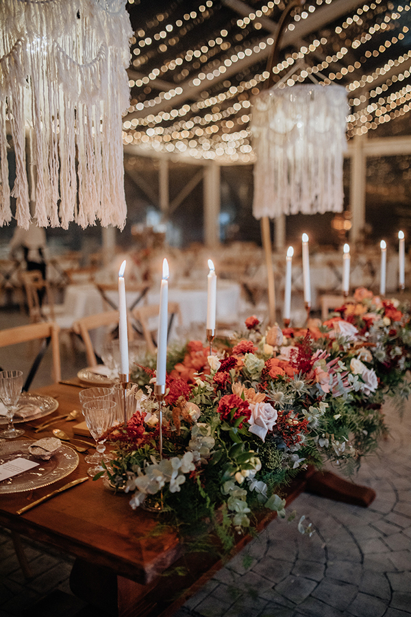 Στολισμός γαμήλιου τραπεζιού με κεριά και λουλούδια σε πορτοκαλί αποχρώσεις