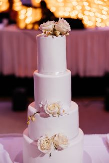 Υπέροχη γαμήλια τούρτα με τέσσερις ορόφους και λευκά τριαντάφυλλα