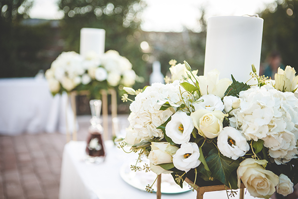 Romantic chic διακόσμηση λαμπάδας γάμου με λευκά άνθη σε χρυσά stand