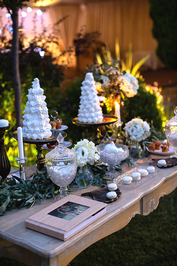 Διακόσμηση dessert table με γιρλάντα από φύλλα ελιάς και λευκά άνθη
