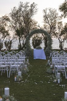 Ultra-romantic στολισμός τελετής γάμου με διάδρομο από κεριά και κυκλική λουλουδένια αψίδα