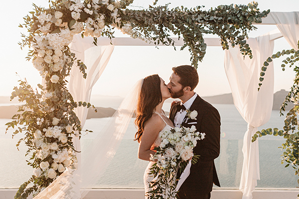 Κομψός καλοκαιρινός γάμος στη Σαντορίνη με λευκά λουλούδια και χρυσές λεπτομέρειες  │ Maryam & Zach
