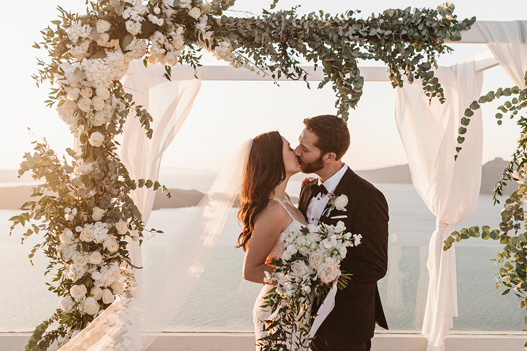 Κομψός καλοκαιρινός γάμος στη Σαντορίνη με λευκά λουλούδια και χρυσές λεπτομέρειες  │ Maryam & Zach