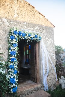 Όμορφος στολισμός εισόδου εκκλησίας με γιρλάντα λουλουδιών από μπλε ορτανσίες