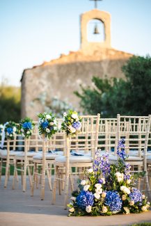 Όμορφος στολισμός καρέκλας γάμου με μπλε ορτανσίες και λευκά τριαντάφυλλα