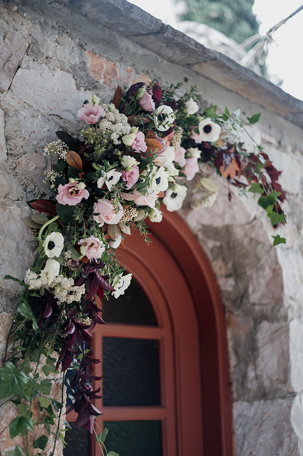 Όμορφος στολισμός εισόδου εκκλησίας με λουλουδένια γιρλάντα από ανεμώνες και τριαντάφυλλα