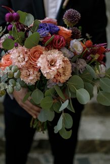 Πλούσια νυφική ανθοδέσμη με μωβ κρασπέδια και τριαντάφυλλα