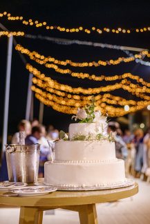 Τριώροφη γαμήλια τούρτα με cake topper από φρέσκα λουλούδια