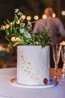 Λευκή γαμήλια τούρτα με χρυσές λεπτομέρειες