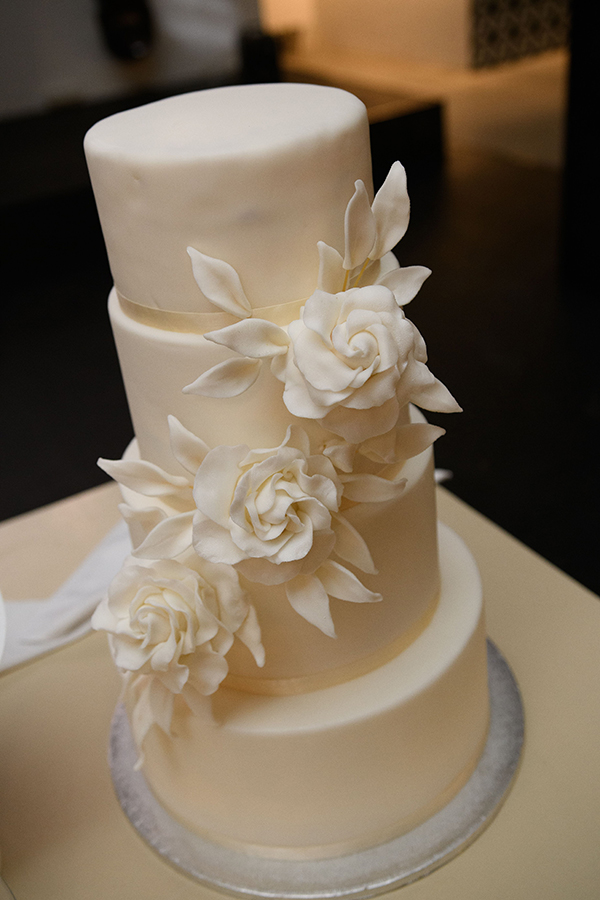 Εντυπωσιακή λευκή γαμήλια τούρτα με λουλούδια από ζαχαρόπαστα