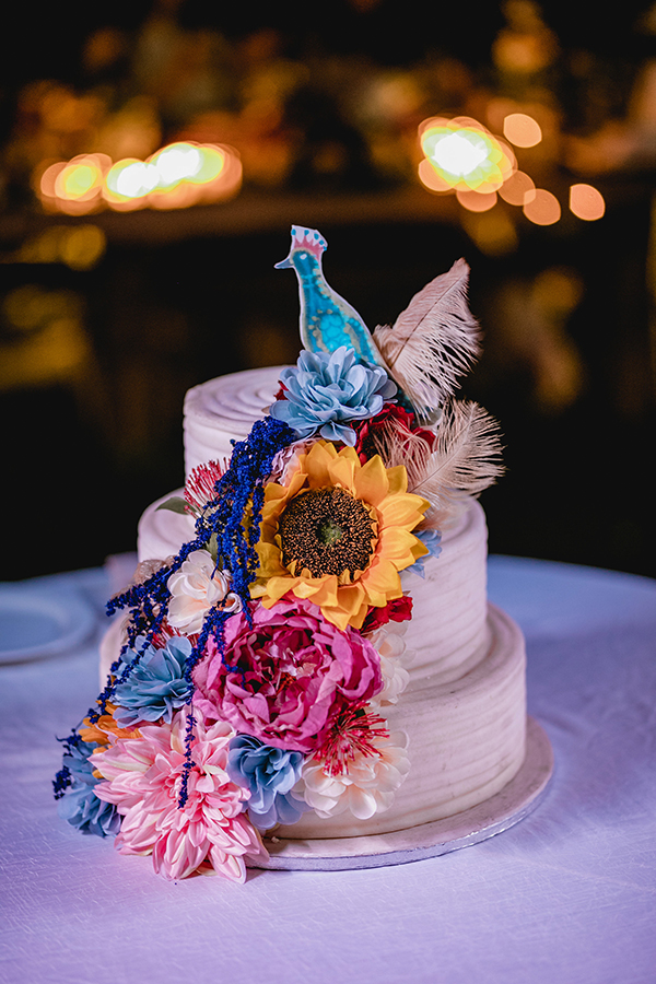 Εντυπωσιακός στολισμός τούρτας γάμου με παγόνι και πολύχρωμα λουλούδια
