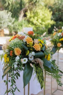Εντυπωσιακός στολισμός γαμήλιας λαμπάδας με ποικιλία λουλουδιών