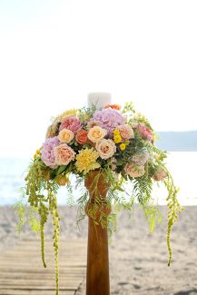 Πολύχρωμη διακόσμηση γαμήλιας λαμπάδας με ροζ ορτανσίες και κίτρινα χρυσάνθεμα