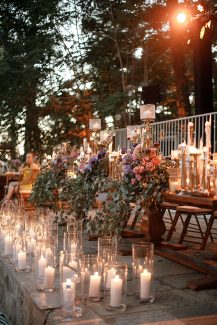 Ρομαντική διακόσμηση γαμήλιου τραπεζιού με πλήθος κεριών και λουλουδιών