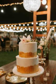 Διώροφη γαμήλια τούρτα με cake topper από φρέσκα λουλούδια