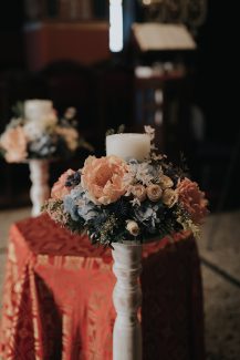 Ρομαντικός στολισμός γαμήλιας λαμπάδας με κοραλί παιώνιες και τριαντάφυλλα