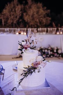 Όμορφη διώροφη γαμήλια τούρτα με κλαδιά ελιάς και λουλούδια