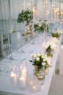 Όμορφος στολισμός γαμήλιου τραπεζιού με λευκά τριαντάφυλλα